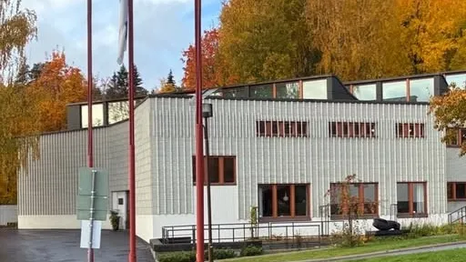 Kuvassa on Alvar Aalto -museo. Taustalla on syksyinen metsä ruskan väreissä.